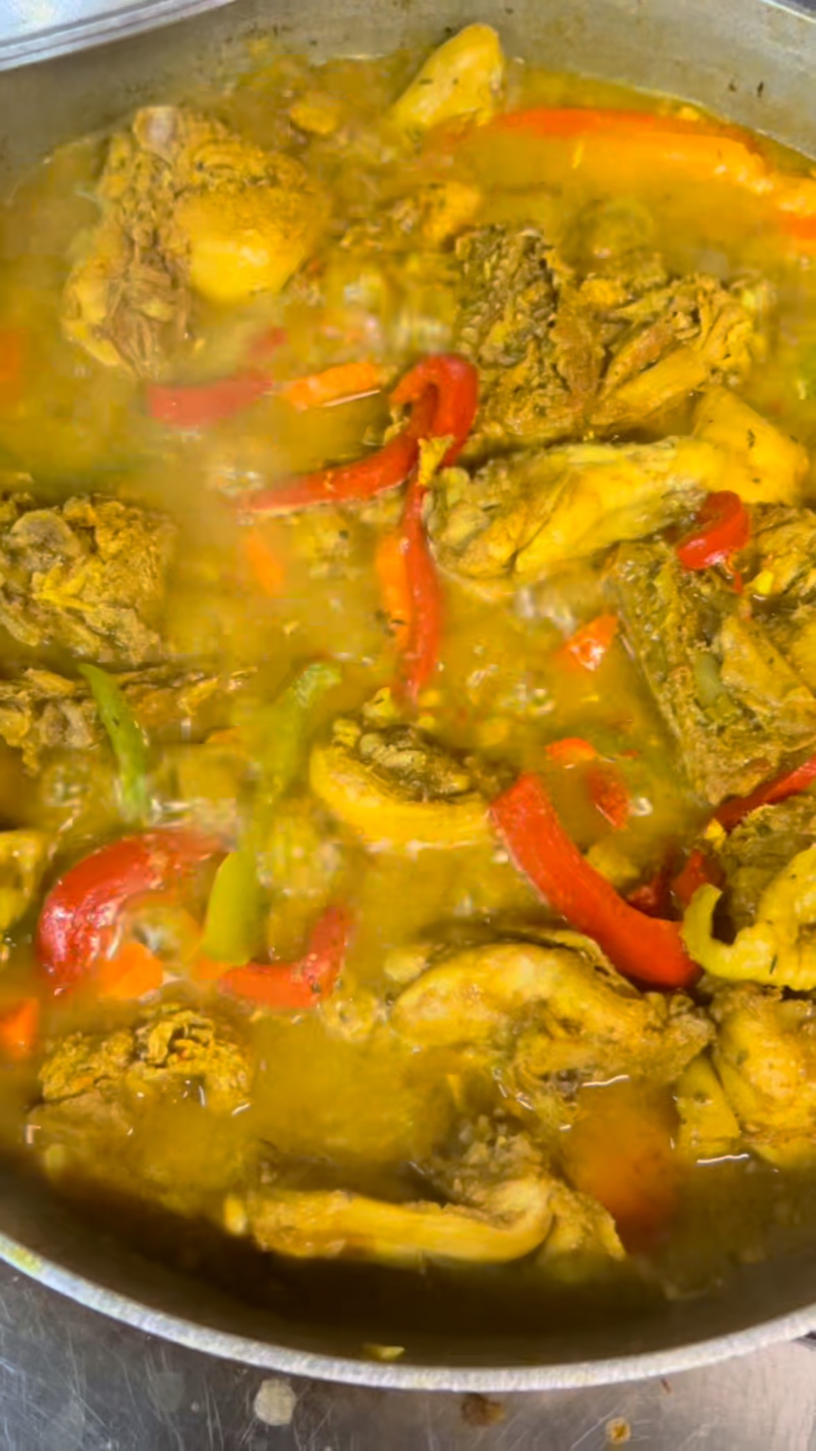 Curry chicken simmering with red and green peppers